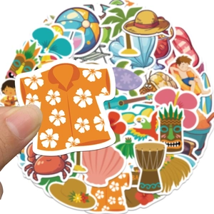 Detail shot of a hand holding a tropical summer sticker with Hawaiian shirt and surfboard