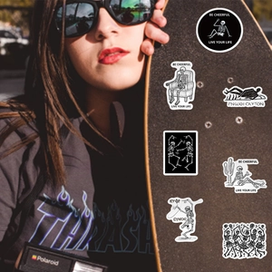 Detail of skull stickers on a skateboard with street style and gothic aesthetic motifs