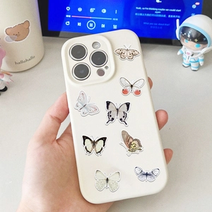 Close-up of white iPhone case featuring detailed butterfly patterns held in hand