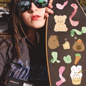 Close-up of cute cartoon animal stickers featuring capybara and bear on a skateboard