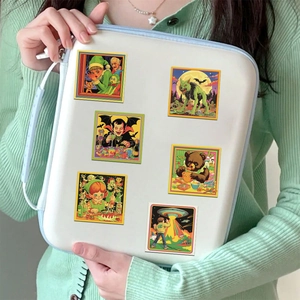Detail of vintage American comic stickers with werewolf and alien art on a white pouch