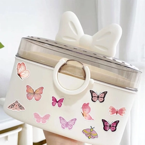 Close-up of white butterfly storage box with bow handle and decorative insect stickers