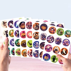 Detailed view of colorful Halloween stickers with pumpkin and ghost motifs on hand
