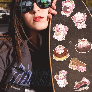 Autocollants de dessin animé axolotl rose mignon décorant la surface d'un skateboard noir