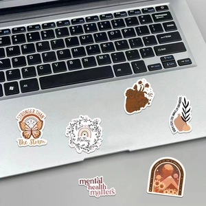 Detail of 6 bohemian mental health stickers with inspirational quotes on a laptop surface