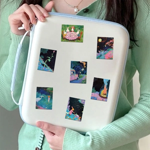 Waterproof fairy tale stickers on a white laptop sleeve held by a woman in a green cardigan