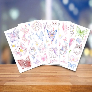Close-up of watercolor cartoon stickers featuring cats and butterflies on wood