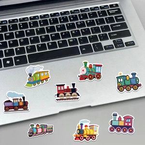 Detailed view of colorful cartoon train stickers applied to a silver laptop surface