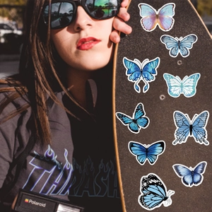Skateboard decorated with blue butterfly stickers showing waterproof PVC texture and wings