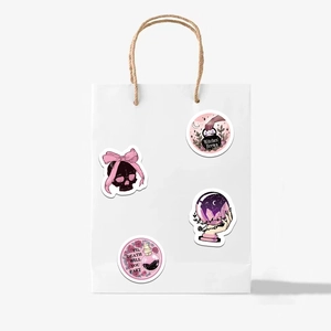 Close-up of gothic witch stickers with skull and potion designs on a white paper bag
