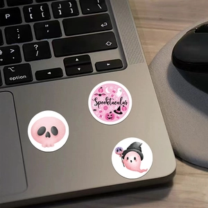 Cute pink Halloween stickers with ghost and skull designs on a laptop surface