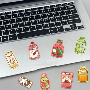 Close-up of cute cartoon summer drink stickers decorated on a silver laptop surface