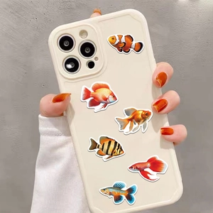 Detailed view of waterproof cartoon tropical fish stickers on a white smartphone case
