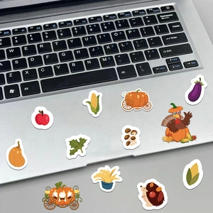 Detail of Thanksgiving stickers featuring pumpkins and turkeys on a laptop surface