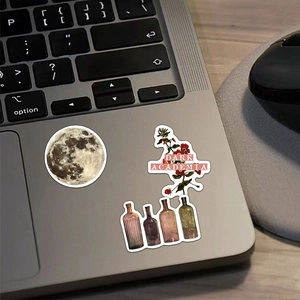Détail de stickers Dark Academia sur ordinateur portable avec motifs lune et fleurs