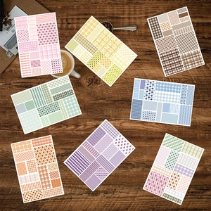 Set of 7 colorful checkered sticky notes for journals on a wooden desk with a coffee cup