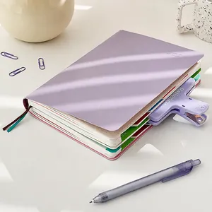 Detalle de agenda morada 2023 con divisores de colores y clip de carpeta a juego