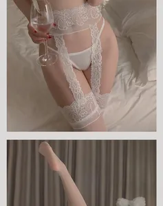 Detailed close-up of white floral lace garter belt with matching stockings on the bed
