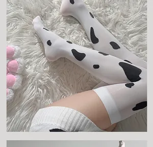Détail de chaussettes hautes au-dessus du genou motif vache sur tapis en peluche