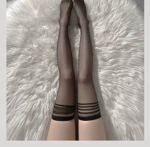 Detail of sheer black thigh-high stockings with triple stripe trim on white plush background
