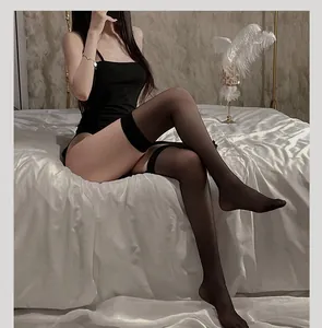 Detailed view of black sheer thigh high stockings with wide non-slip cuffs on white satin