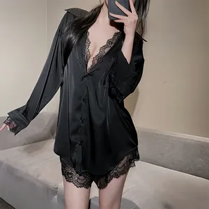 Détail d'un pyjama en satin noir avec chemise à col en V profond et short en dentelle