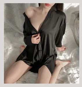 Détail du tissu en satin noir brillant et des boutons à simple boutonnage de la chemise
