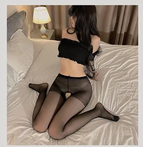 Detailed view of sheer black crotchless tights with elastic fit in a bedroom setting