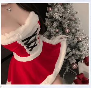 Détail de la robe de Noël en velours rouge avec bordure en fourrure et laçage noir