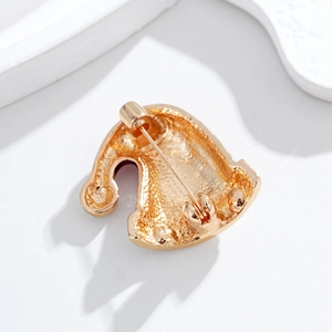 Back view of a gold Christmas hat brooch showing pin structure and metal texture