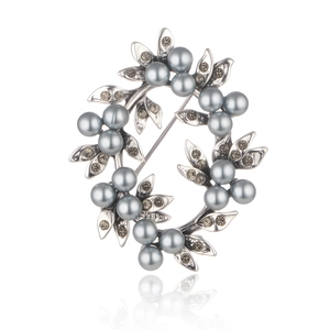 Detailed view of silver-toned flower wreath brooch with grey pearls and crystals