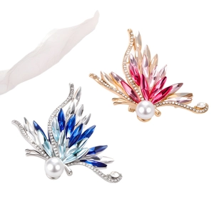 Spilla a farfalla elegante con strass sfumati e perle bianche su sfondo bianco