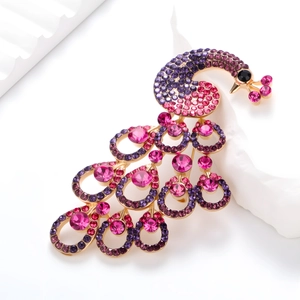 Detail of vintage peacock brooch with purple rhinestones on a gold plated base