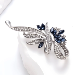 Détail macro d'une broche argentée avec pierres marquise bleu marine et cristaux