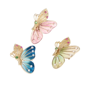 Drei farbenfrohe Vintage-Schmetterlingsbroschen mit Emaille, Perlen und Strass auf weißem Grund