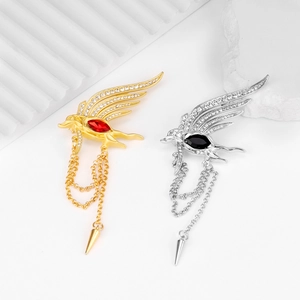 Macro shot of twin bird brooches featuring crystal wings and elegant metal chain tassels