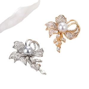 Elegant floral pearl brooch with sparkling diamonds and hanging tassels in gold and silver