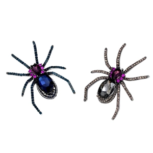 Gothic crystal spider brooches in blue and grey rhinestones set on a white background
