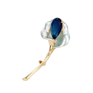 Élégante broche Arum avec pierre bleue en poire et pétales argentés sur fond blanc