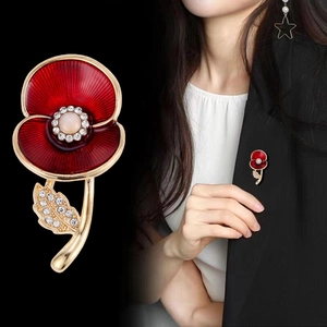 Elegant red enamel poppy brooch with rhinestones and gold leaf on black background
