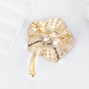 Back view of gold poppy flower brooch with full pavé crystals and hammer textured finish