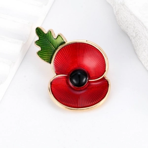 British remembrance red poppy brooch pin with enamel petals and green leaf on white background