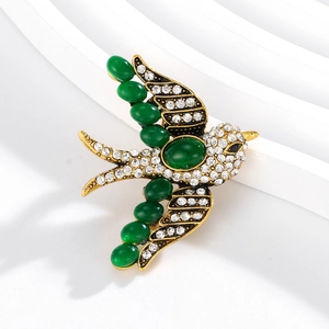 Exquisite swallow bird brooch with green gemstones and white rhinestones in gold setting