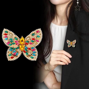 Élégante broche papillon en cristal avec strass colorés sur une base dorée