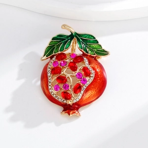 Nahaufnahme der Granatapfel-Brosche mit roten Edelsteinen und grünem Emaille-Blatt