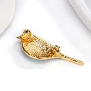 Gouden vogelspeld achterkant met metalen sluiting op een witte achtergrond details