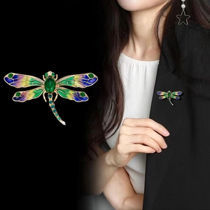 Broche libellule élégante avec ailes en émail coloré et pierre verte sur costume noir
