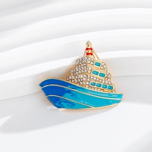 Macro shot of cruise ship brooch with blue enamel and sparkling rhinestones on the wave base