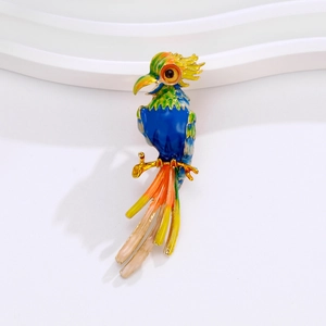 Vibrant enamel parrot brooch in blue and green with gold plating on white background