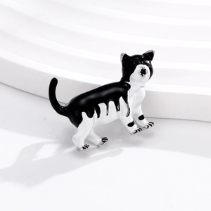 Broche chat émaillée noir et blanc avec bords métalliques argentés en pose de marche